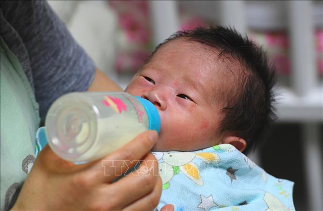 Trong ảnh: Nhân viên xã hội chăm sóc em bé sơ sinh tại Seoul, Hàn Quốc. Ảnh: AFP/TTXVN