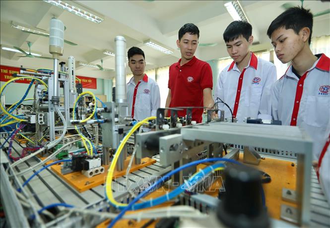 Thầy Cao Hồng Long giới thiệu mô hình tự động hoá cho sinh viên Lớp điện tử công nghiệp K13. Ảnh: Hoàng Hiếu - TTXVN
