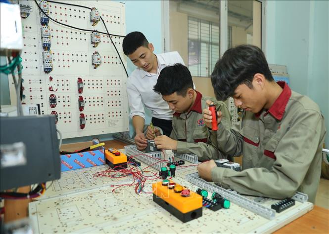 Thầy Hoàng Đức Long hướng dẫn sinh viên khoa cao đẳng điện tử khoá 13 lắp đặt điện công nghiệp. Ảnh: Hoàng Hiếu - TTXVN