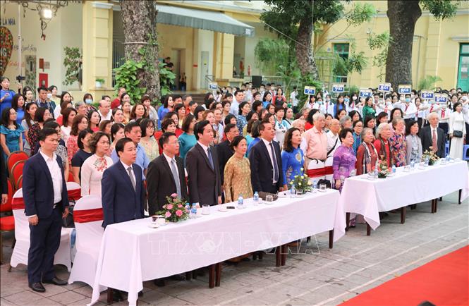 Đại biểu dự lễ cùng giáo viên, học sinh trường THCS Trưng Vương thực hiện nghi thức chào cờ. Ảnh: Thanh Tùng TTXVN 