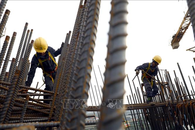 Công nhân lặp đặt cốt thép trên đốt S30/33 của trụ tháp chính T15. Ảnh: Huy Hùng - TTXVN