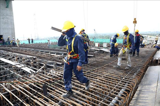 Hàng chục kỹ sư, công nhân thi công trên trụ tháp T15 ở độ cao hơn 100 m. Ảnh: Huy Hùng - TTXVN