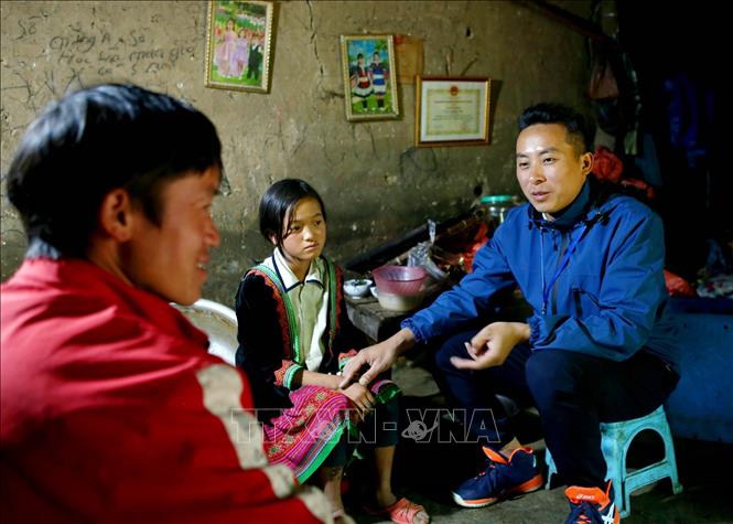 Thầy giáo Nguyễn Văn Tuân xuống bản vận động phụ huynh cho con em đi học, góp phần nâng cao tỷ lệ chuyên cần của Trường PTDTBT Tiểu học và Trung học cơ sở Tung Qua Lìn. Ảnh: Quý Trung – TTXVN