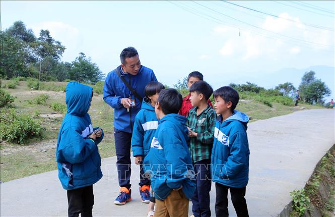 Không chỉ ân cần trên lớp, khi ra về thầy cũng luôn quan tâm đến học sinh, chia sẻ động viên học sinh đến trường. Ảnh: Quý Trung – TTXVN