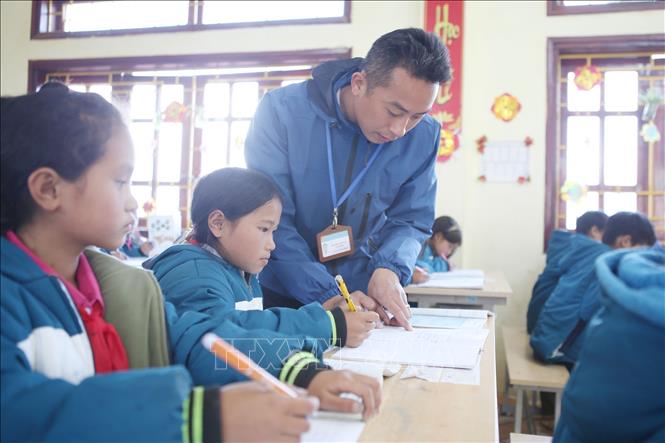 Thầy giáo Nguyễn Văn Tuân hướng dẫn học sinh làm bài tập toán tại Trường PTDTBT Tiểu học và Trung học cơ sở Tung Qua Lìn. Ảnh: Quý Trung – TTXVN