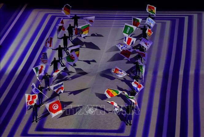 Trong ảnh: Các nghệ sĩ trình diễn quốc kỳ của 32 đội tuyển tham gia tranh tài tại World Cup 2022 trong lễ khai mạc giải đấu, trên sân Al-Bayt ở Al Khor, Qatar ngày 20/11/2022. Ảnh: AFP/TTXVN