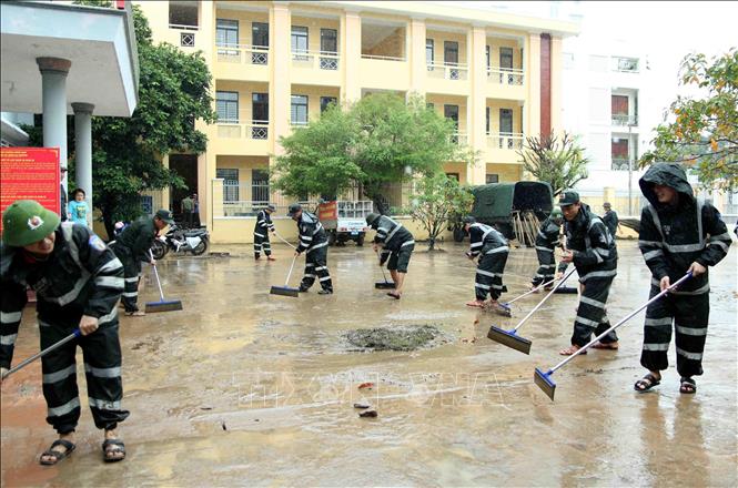 Lực lượng Cảnh sát cơ động tham gia dọn dẹp, vệ sinh sau trận mưa lũ tại UBND Phường Ghềnh Ráng,Tp Quy Nhơn, Bình Định. Ảnh: TTXVN phát