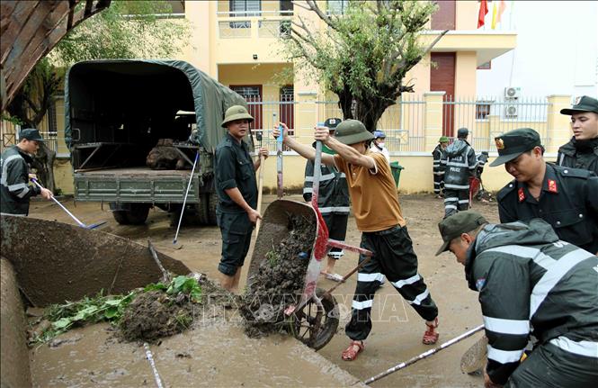 Lực lượng Cảnh sát cơ động tham gia dọn dẹp, vệ sinh 1 đoạn đường tại Phường Ghềnh Ráng,Tp Quy Nhơn, Bình Định sau trận mưa lũ. Ảnh: TTXVN phát