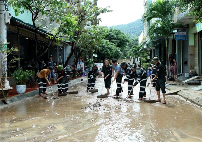 Lực lượng Cảnh sát cơ động tham gia dọn dẹp, vệ sinh 1 đoạn đường tại Phường Ghềnh Ráng,Tp Quy Nhơn, Bình Định sau trận mưa lũ. Ảnh: TTXVN phát