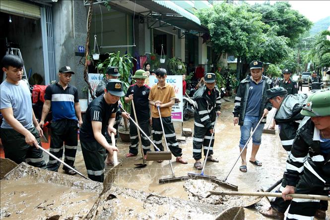 Lực lượng Cảnh sát cơ động tham gia dọn dẹp, vệ sinh 1 đoạn đường tại Phường Ghềnh Ráng,Tp Quy Nhơn, Bình Định sau trận mưa lũ. Ảnh: TTXVN phát