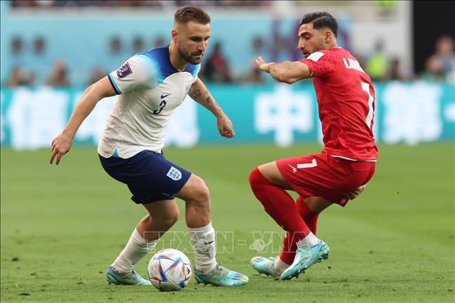 Hậu vệ Luke Shaw (trái) đội Anh tranh bóng với trung vệ Alireza Jahanbakhsh (phải), đội Iran. Ảnh: AFP/TTXVN