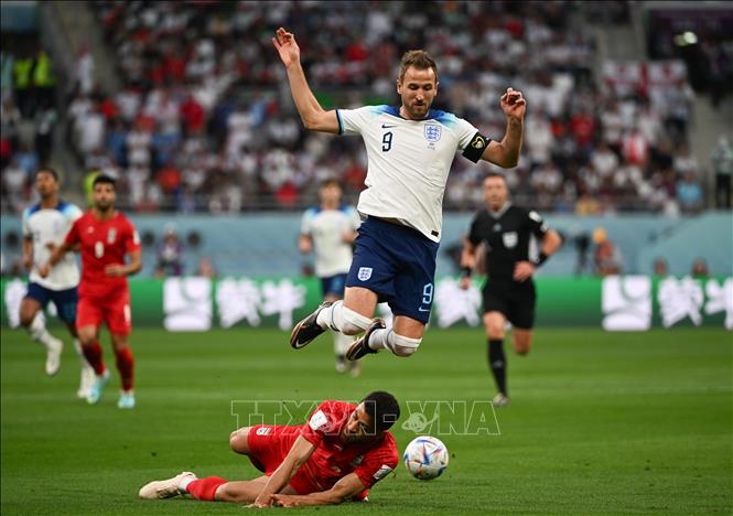 Pha vào bóng quyết liệt của hậu vệ Iran để ngăn cản đường lên bóng của Harry Kane, đội tuyển Anh. Ảnh: THX/TTXVN