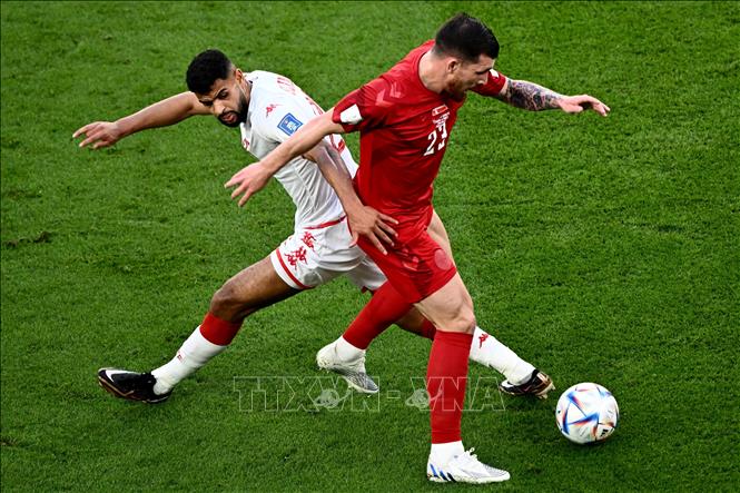 Đan Mạch tổ chức tấn công, khoét khá nhiều vào bên cánh trái của Tunisia, nhưng lối đánh này của đội bóng châu Âu vẫn chưa hiệu quả. Trong ảnh: Pha tranh bóng quyết liệt giữa tiền vệ Đan Mạch Pierre-Emile Hojbjerg (phải) và tiền đạo Tunisia Anis Ben Slimane. Ảnh: AFP/ TTXVN