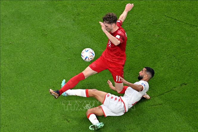 Kết thúc Hiệp 1, hai đội tạm hòa với tỉ số 0-0. Trong ảnh: Pha tranh bóng giữa tiền vệ Andreas Skov Olsen (trái) của Đan Mạch và hậu vệ Ali Abdi của Tunisia trong trận đấu. Ảnh: AFP/ TTXVN