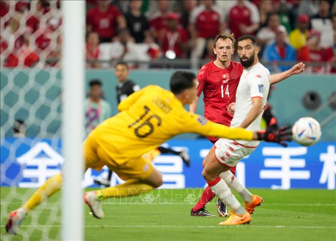 Trong ảnh: Pha cứu thua của thủ thành Tunisia Aymen Dahmen (trái) sau cú sút của cầu thủ Đan Mạch Mikkel Damsgaard (giữa) trong trận đấu. Ảnh: THX/ TTXVN