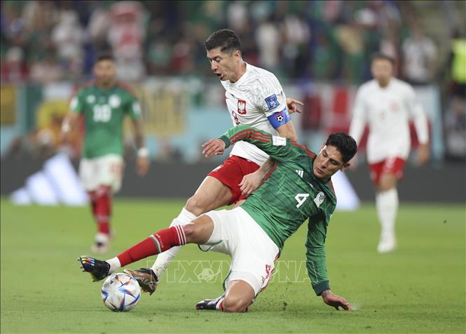 Trong ảnh: Pha tranh bóng quyết liệt giữa tiền đạo Ba Lan Robert Lewandowski (trái) với tiền vệ Edson Alvarez của Mexico. Ảnh: THX/TTXVN