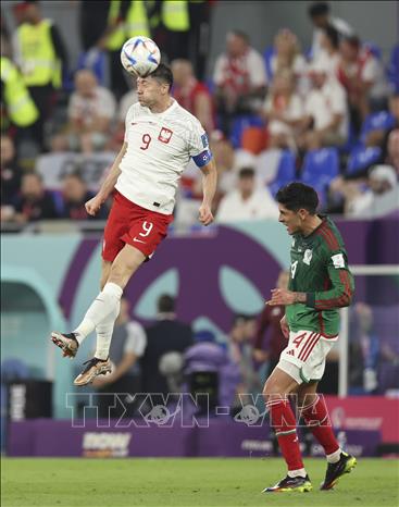 Trong ảnh: Tiền đạo Ba Lan Robert Lewandowski (trái) đánh đầu trong trận đấu gặp Mexico. Ảnh: THX/TTXVN