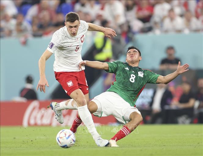 Trong ảnh: Tiền vệ Ba Lan Krystian Bielik (trái) trong pha tranh bóng với tiền vệ Mexico Carlos Rodriguez. Ảnh: THX/TTXVN