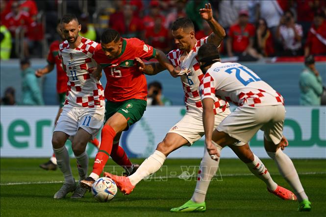 Trong ảnh: Tiền vệ Selim Amallah (số 15), đội tuyển Maroc đi bóng trước sự cản phá quyết liệt của các cầu thủ Croatia. Ảnh: AFP/TTXVN