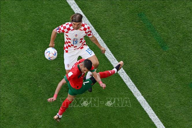 Trong ảnh: Hậu vệ Borna Sosa (số 19 ) đội tuyển Croatia tranh bóng  với tiền vệ Hakim Ziyech (số 7), đội Maroc. Ảnh: AFP/TTXVN