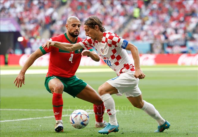 Trong ảnh: Luka Modric (phải), đội Croatia tranh bóng với  Sofyan Amrabat, đội Maroc. Ảnh: THX/TTXVN