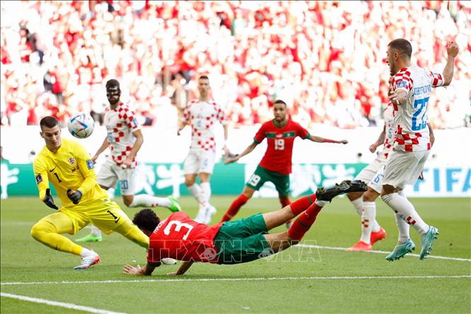 Trong ảnh: Thủ môn Dominik Livakovic (trước trái), đội Croatia cản phá thành công cú sút của Noussair Mazraoui (trước giữa), đội Maroc. Ảnh: THX/TTXVN