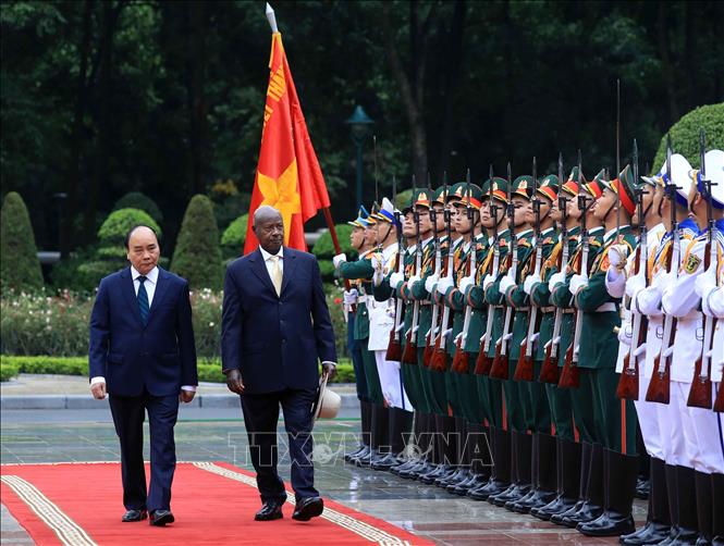 President Nguyen Xuan Phuc and Ugandan President Yoweri Kaguta Museveni review the guards of honour at the welcome ceremony in Hanoi on November 24. VNA Photo