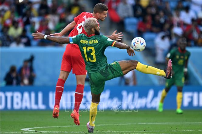Pha tranh bóng giữa tiền đạo Eric Maxim Choupo-Moting (số 13) của Cameroon và hậu vệ Nico Elvedi của Thụy Sĩ. Ảnh: AFP/TTXVN