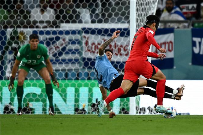 Phút 51, Son Heung-min (phải) bỏ lỡ cơ hội ghi bàn trong vòng 16m50 khi hậu vệ Uruguay Jose Maria Gimenez (trái) kịp ra chân cản phá cú dứt điểm của tiền đạo đội Hàn Quốc. Ảnh: AFP/ TTXVN