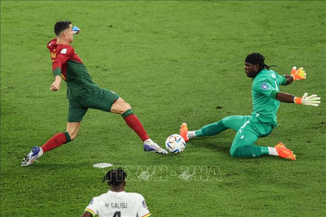 Cristiano Ronaldo (trái) của Bồ Đào Nha đối mặt thủ môn Ghana Lawrence Ati Zigi. Ảnh: THX/TTXVN