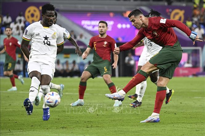 Cầu thủ đội Ghana (trái) cản phá cú sút của Cristiano Ronaldo (phải), đội Bồ Đào Nha. Ảnh: THX/TTXVN