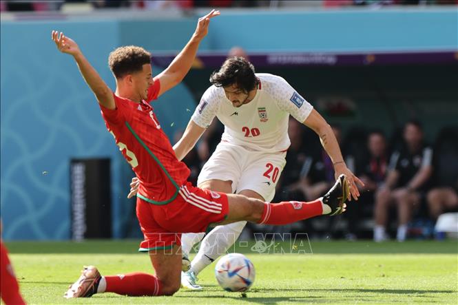 Trong ảnh: Hậu vệ Ethan Ampadu (trái - số 15) đội tuyển Xứ Wales tranh bóng với tiền đạo Sardar Azmoun (phải - số 20), đội tuyển Iran. Ảnh: AFP/TTXVN