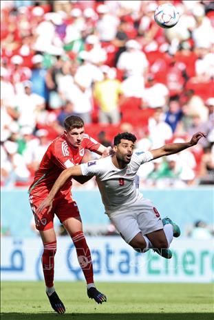 Trong ảnh: Hậu vệ Chris Mepham (trái- số 5) đội tuyển Xứ Wales tranh bóng với tiền đạo Mehdi Taremi (số 9), đội tuyển Iran. Ảnh: AFP/TTXVN