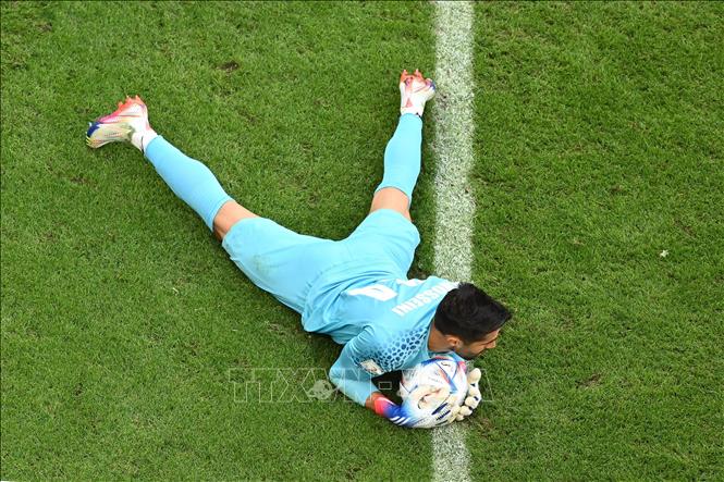 Trong ảnh: Thủ môn đội tuyển Iran Hossein Hosseini cản phá thành công cú sút của cầu thủ đội tuyển Xứ Wales. Ảnh: AFP/TTXVN