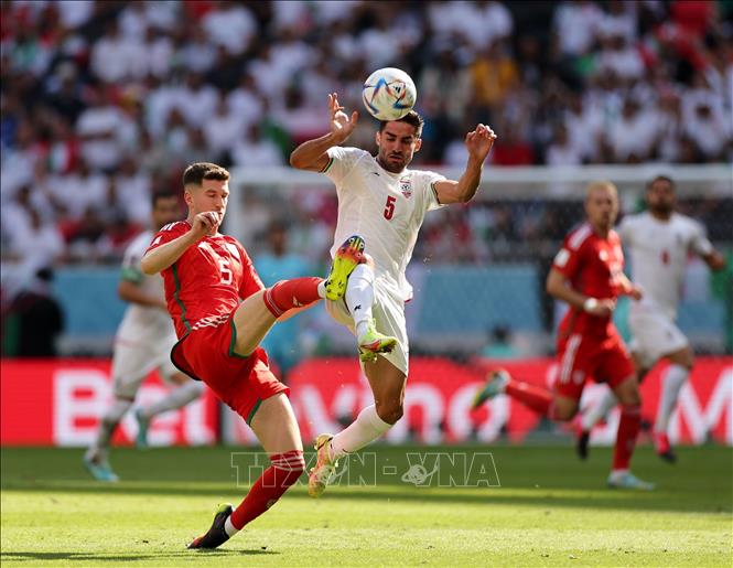 Trong ảnh: Chris Mepham (trái) đội tuyển Xứ Wales tranh bóng với Milad Mohammadi (phải) đội tuyển Iran. Ảnh: THX/TTXVN