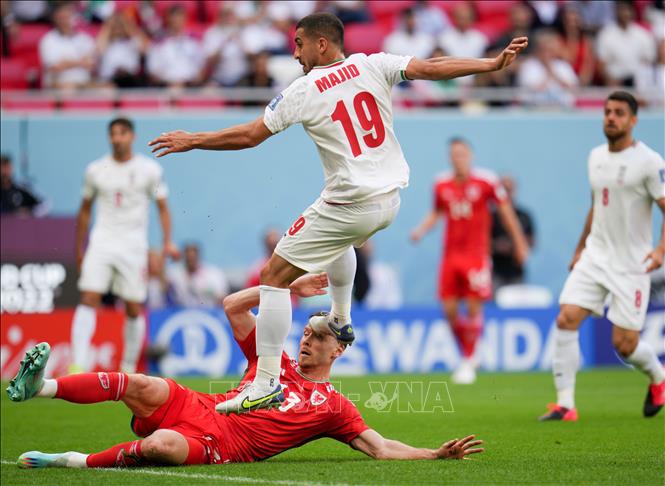Trong ảnh: Kieffer Moore (phía trên), đội tuyển Xứ Wales tranh bóng với Majid Hosseini, đội tuyển Iran. Ảnh: THX/TTXVN
