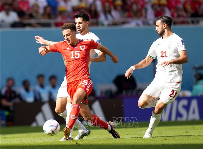 Trong ảnh: Cầu thủ  Ethan Ampadu (phía trước), đội tuyển Xứ Wales đi bóng trước sự cản phá của các cầu thủ Iran. Ảnh: THX/TTXVN