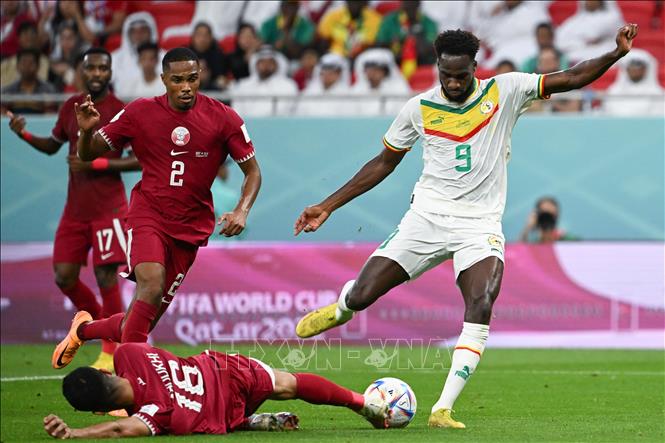 Tận dụng sai lầm của hậu vệ Qatar Boualem Khoukhi, tiền đạo Boulaye Dia (9, phải) dứt điểm hiểm hóc, mở tỷ số cho Senegal. Ảnh: AFP/TTXVN