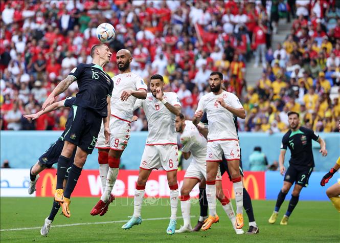 Mitchell Duke (trái) của Australia bật cao đánh đầu trước các cầu thủ Tunisia. Ảnh: THX/TTXVN