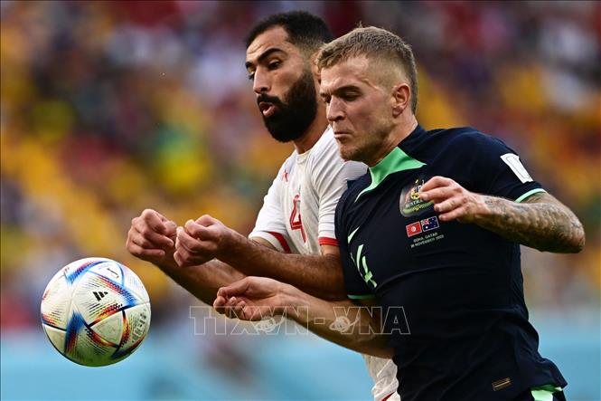 Hậu vệ Yassine Meriah (trái) của Tunisia tranh bóng với tiền vệ Riley McGree của Australia. Ảnh: AFP/TTXVN