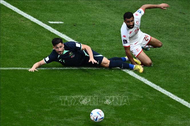 Tiền đạo Mathew Leckie (trái) của Australia tranh bóng với hậu vệ Ali Abdi của Tunisia. Ảnh: AFP/TTXVN