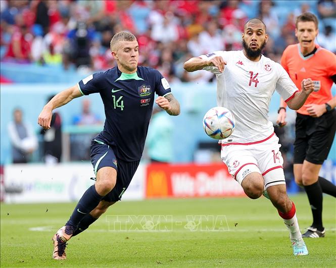 Riley McGree (trái) của Australia tranh bóng với Aissa Laidouni của Tunisia. Ảnh: THX/TTXVN