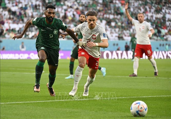 Tiền đạo Firas Al-Buraikan (trái - Saudi Arabia) đột phá và căng ngang từ cánh phải, tuy nhiên đường chuyền vào đã bị hậu vệ Matthew Cash của Ba Lan cản phá. Ảnh: AFP/ TTXVN