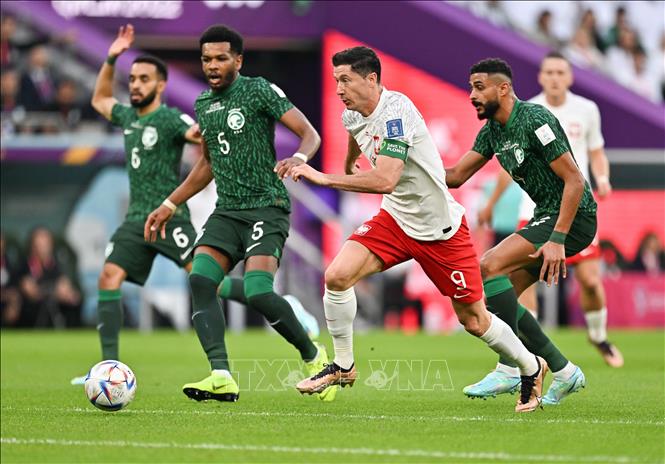 Tiền đạo Ba Lan Robert Lewandowski (giữa) khéo léo dẫn bóng vượt qua sự truy cản của các cầu thủ Saudi Arabia. Ảnh: THX/ TTXVN