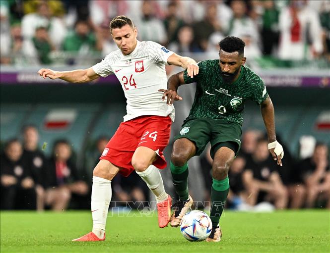 Przemyslaw Frankowski (trái) tuyển Ba Lan tranh bóng với Feras Albrikan tuyển Saudi Arabia. Ảnh: THX/ TTXVN