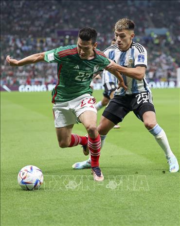 Cầu thủ Mexico Hirving Lozano (trái) đi bóng trước sự truy cản của Lisandro Martinez (Argentina). Ảnh: THX/TTXVN