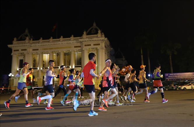 Các VĐV chạy trên Quảng trường Cách mạng tháng Tám, trước Nhà hát lớn Hà Nội. Ảnh: Hoàng Hiếu - TTXVN 