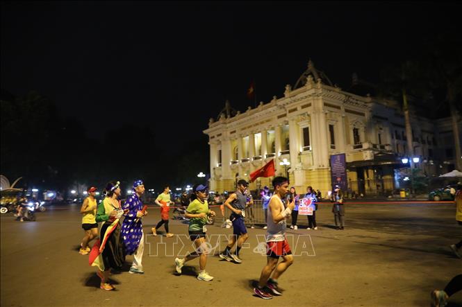 Các VĐV chạy trên Quảng trường Cách mạng tháng Tám, trước Nhà hát lớn Hà Nội. Ảnh: Hoàng Hiếu - TTXVN 