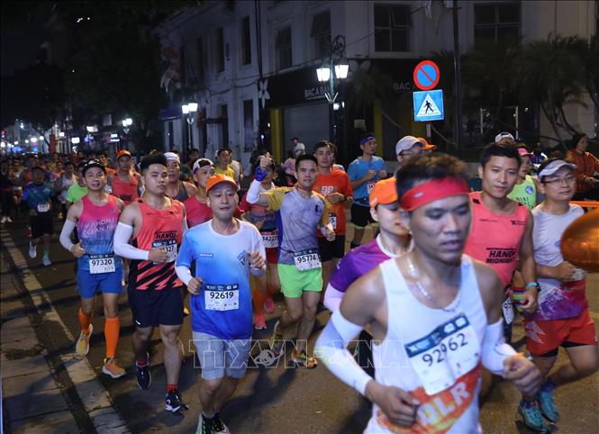 Các VĐV chạy trên phố Tràng Tiền lúc nửa đêm. Ảnh: Hoàng Hiếu - TTXVN 