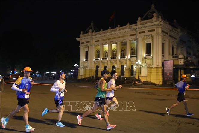 Các VĐV chạy trên Quảng trường Cách mạng tháng Tám, trước Nhà hát lớn Hà Nội. Ảnh: Hoàng Hiếu - TTXVN 